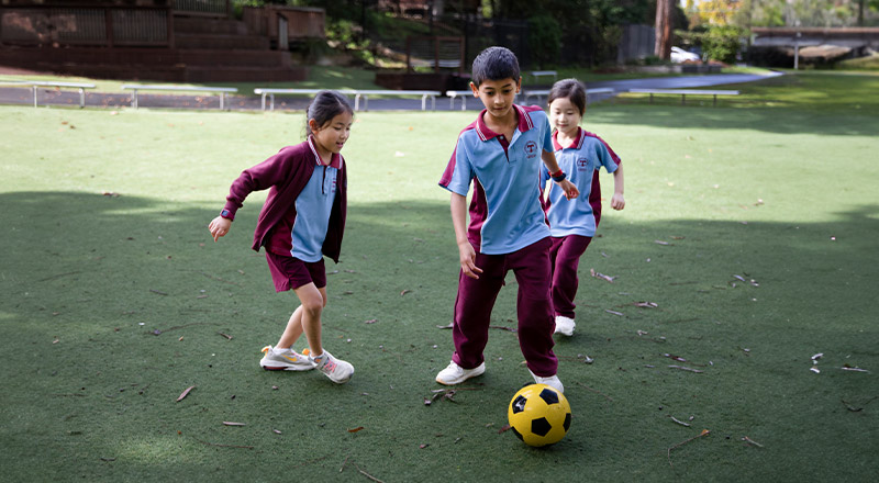 Students playing soccer together on the school oval at St Bernadette's Primary School Dundas Valley