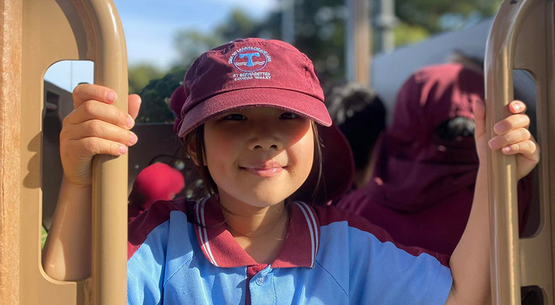 A student smiling on the playground at St Bernadette's Primary School Dundas Valley
